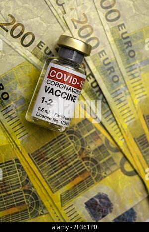Vaccino Covid-19 accanto a diverse duecento banconote in euro, immagine concettuale Foto Stock