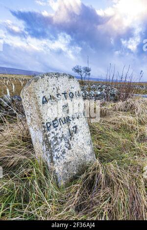 Una vecchia pietra miliare sulle North Pennines in inverno vicino ad Alston, Cumbria UK Foto Stock