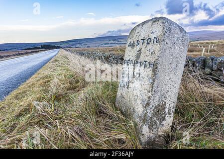 Una vecchia pietra miliare sulle North Pennines in inverno vicino ad Alston, Cumbria UK Foto Stock