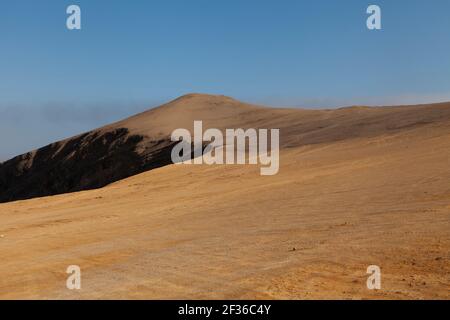 Fotografia paesaggistica di dune rosse e sabbie, vicino alle scogliere, nel deserto di Paracas, sulla strada Lagunillas, in direzione della spiaggia di Las Minas in Foto Stock