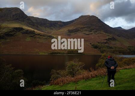 Un fotografo che prende un'immagine al lago Buttermere nel Lake District, Cumbria. Foto Stock