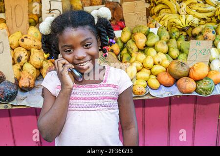 Santo Domingo Repubblica Dominicana, Ciudad Colonia zona coloniale, Calle Palo Hincado frutta produrre stand stallo, ispanica ragazza nera parlare cellulare pho Foto Stock