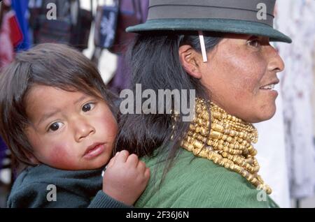 Ecuador Equadoriano Sudamerica America americana mercato di Otavalo, madre donna femmina bambino che indossa perle indigene, Foto Stock