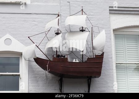 decorazione della nave a vela sul lato di una casa imbiancata Nella baia di Porlock Foto Stock