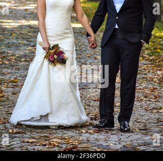 Una romantica coppia appena sposata in giardino, giorno di matrimonio romantico, senza viso Foto Stock