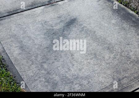 Marciapiede di cemento sporco di fronte a una casa che ha bisogno di lavaggio a pressione. Foto Stock