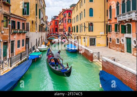 Tipico canale con gondola durante un episodio di acqua alta, a Venezia in Veneto, Italia Foto Stock