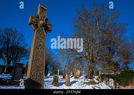 Croce celtica contro un cielo blu in un cimitero di Warriston, Edimburgo, Scozia, Regno Unito. Foto Stock
