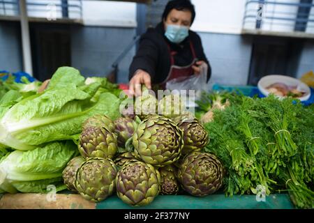 Una donna che indossa una maschera protettiva, vende verdure in un mercato all'aperto di strada a Patrasso Grecia. Credit: Dimitris Aspiotis / Alamy Foto Stock