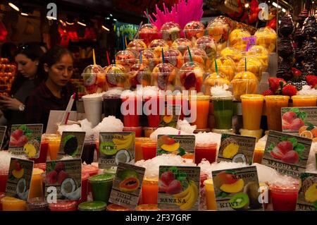 BARCELLONA, SPAGNA - 10 MARZO 2018: Famoso mercato alimentare di Barcellona la Boqueria. I clienti scelgono succhi di frutta fresca, frullati e insalate di frutta Foto Stock