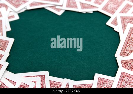 Immagine di un tavolo verde per giochi di carte, circondato dai bordi con le carte da un mazzo, lasciando il centro libero per aggiungere testo o grafica (spazio di copia Foto Stock