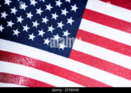 Una macro con messa a fuoco selettiva di una piccola bandiera americana portatile su tessuto grezzo. Foto Stock