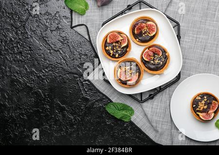 Tartlet con gustosa pasta di cioccolato e fichi su sfondo scuro Foto Stock