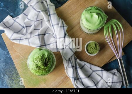 Composizione con gustoso latte di dalgona matcha sul tavolo Foto Stock