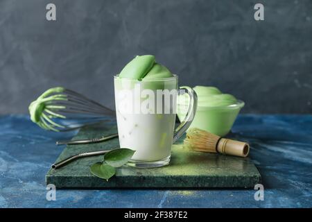 Composizione con gustosa dalgona matcha latte su sfondo colorato Foto Stock