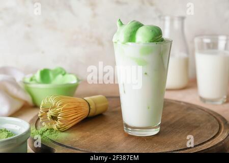 Composizione con gustoso latte di dalgona matcha sul tavolo Foto Stock