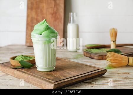 Composizione con gustoso latte di dalgona matcha su sfondo ligneo Foto Stock