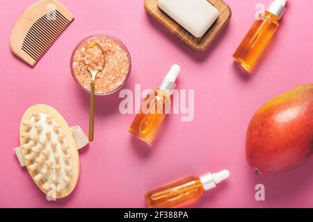 Composizione con olio essenziale di mango e prodotti da bagno a colori sfondo Foto Stock