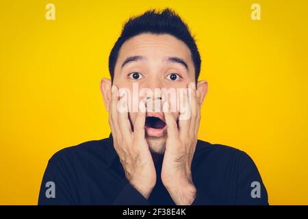 Un uomo che esprime il volto scioccato e spaventato, feeling e concetto di emozione - effetto tono vintage Foto Stock