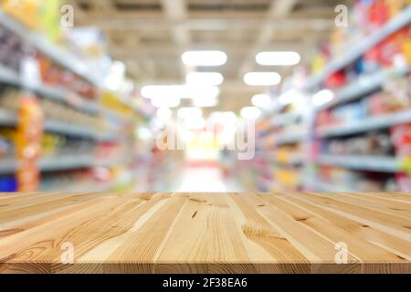 Tavolo in legno su sfondo blur supermercato - può essere utilizzato per la visualizzazione o il montaggio dei prodotti Foto Stock