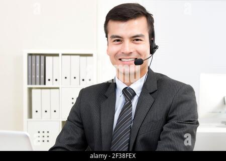 Sorridente bell'uomo d'affari che indossa cuffie con microfono - concetti di telemarketing, operatore, call center e personale di assistenza clienti Foto Stock