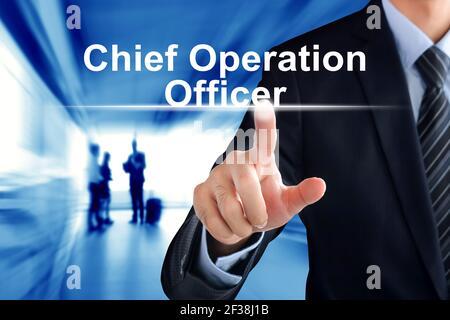 Mano di un uomo d'affari che tocca il Chief Operation Officer (o COO) accedere alla schermata virtuale Foto Stock