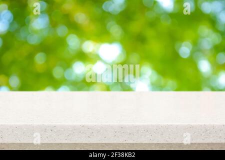 Piano di contrasto in pietra bianca su sfondo astratto bokeh verde naturale fresco - può essere utilizzato per la visualizzazione o il montaggio dei prodotti Foto Stock