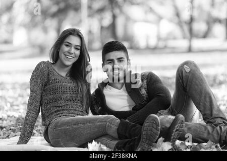 Giovane coppia seduta su una coperta nel bell'autunno Giorno Foto Stock