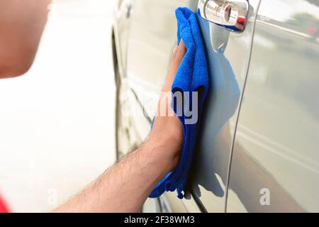 Un uomo auto lucidante con panno in microfibra Foto Stock