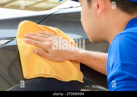 Un uomo lucidare auto con il tessuto di microfibra, l'automobile che descrive (o valeting) concetto Foto Stock