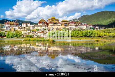 Ganden Sumtseling monastero panoramica con lago e acqua riflessione In Cina Shangri-la Yunnan Foto Stock