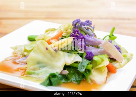 Mescolare le verdure colorate fritte in piatti bianchi in stile asiatico Foto Stock