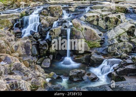 Delicate cascate che cadono attraverso un paesaggio di rocce mussose ed erose. McLaren Falls Park, Nuova Zelanda Foto Stock