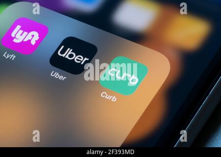 Le icone delle app Uber e Curb Ridesharing vengono visualizzate su un iPhone. Foto Stock