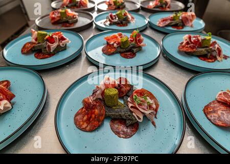 Piatto con prosciutto spagnolo di serrano servito con pane al carbone nero e burro stagionato, cucina raffinata Foto Stock