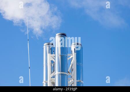 tre tubi con fumo bianco contro il cielo blu. Foto di alta qualità Foto Stock