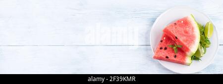 Fette di anguria sul piatto su tavola bianca Foto Stock