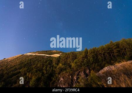 Vista ad angolo basso del cielo stellato sopra la montagna coperta di albero, Canyon Matka, Skopje, Macedonia del Nord Foto Stock