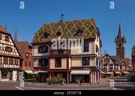 Obernai (Francia nord-orientale): Casa tradizionale e tetto con piastrelle smaltate, e il campanile Kappelturm (Torre della Cappella) sullo sfondo, campanile o Foto Stock