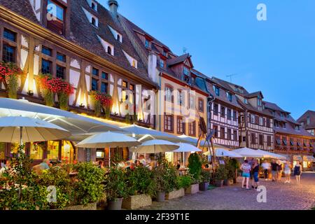 Obernai (Francia nord-orientale): Terrazze di ristoranti e facciate di case a graticcio in serata Foto Stock