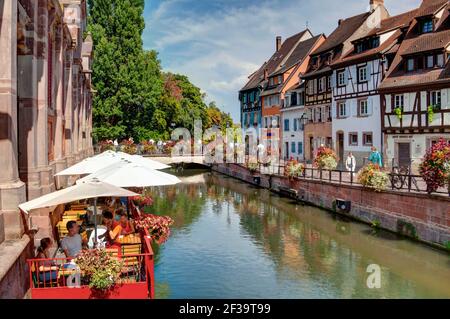 Colmar (Francia nord-orientale): Facciate di case a graticcio, case tradizionali alsaziane, banchina "quai de la Poissonnerie". Turisti sulla terrazza o Foto Stock