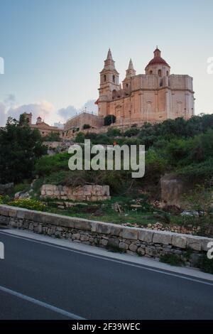 Strada accanto alla Chiesa Parrocchiale della Natività della Vergine Maria a Mellieha, Malta in una serata d'autunno. Foto Stock