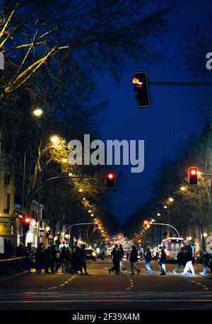 Pedonale che attraversa una strada trafficata di notte a Madrid, Spagna Foto Stock