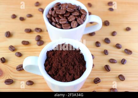 Tazza di caffè macinato con una tazza di caffè arrosto Fagioli sullo sfondo Foto Stock