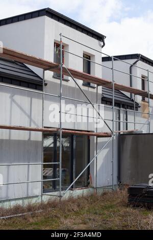 Moderna costruzione di case con impalcatura piattaforma palo. Edificio domestico di nuova costruzione. Foto Stock