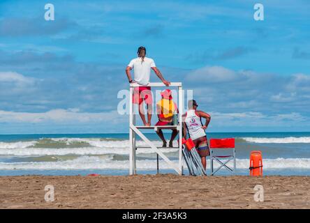 MAR AZUL, ARGENTINA - 18 febbraio 2021: Tre bagnini che guardano al mare Mar Azul, costa atlantica Argentina. Foto Stock