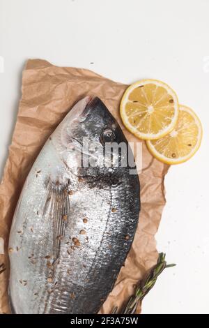 Pesce dorada crudo o orata a testa dorata su sfondo bianco, piatto, vista dall'alto Foto Stock