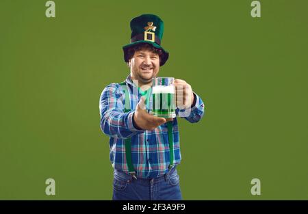 Sorridente irlandese in cappello di Patrick che tiene una pinta di birra di vetro isolato su sfondo verde Foto Stock