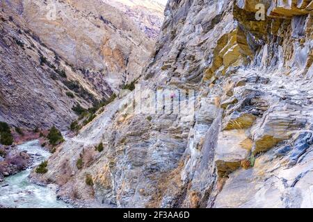 Trekking sul circuito di Dolpo trekking nella regione tipicamente tibetana occidentale del Nepal di Dolpo. Percorso tagliato da scogliera sopra il fiume Foto Stock