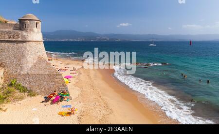 Ajaccio, Francia - 25 agosto 2018: Paesaggio costiero dell'isola di Corsica, fortezza la Citadelle e la gente su una spiaggia di sabbia Foto Stock